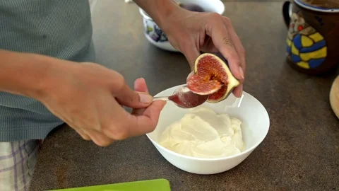 Girl scooping out fig with a spoon Stock Footage 101757341