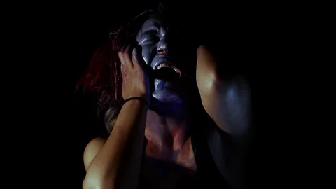 Girl screams in horror while acting weird with makeup on face Stock Footage 123097799