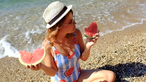 Girl on the sea eats a slice of watermelon Stock Footage 95877299