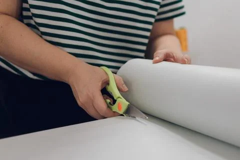 Girl seamstress cuts fabric with scissors Stock Photos