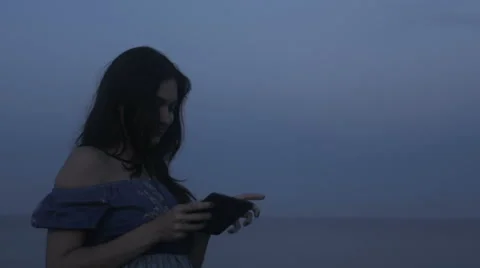 The girl at seaside using the mini tablet Stock Footage 64696549