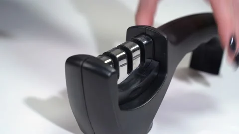 A girl sharpens a knife with a sharpener Stock-Footage 119549444