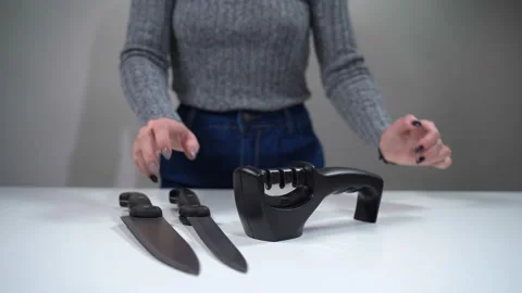 A girl sharpens a knife with a sharpener 動画素材 119549545