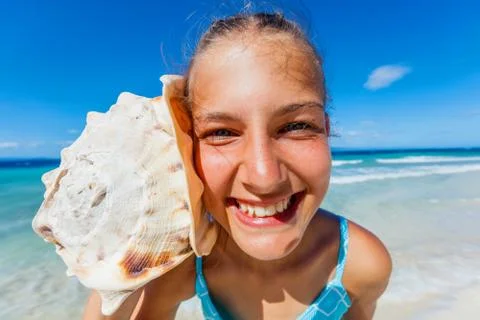 Girl with shell at the beach Photos