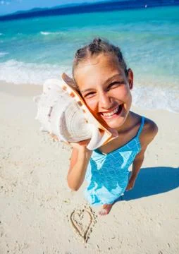 Girl with shell at the beach Fotos Stock