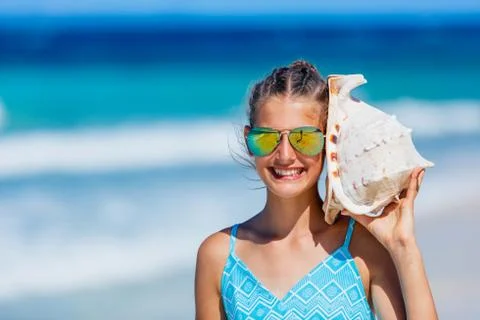 Girl with shell at the beach 写真素材