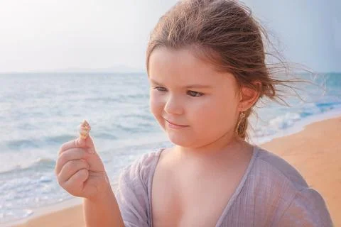 Girl with shell on the beach Stock Photos
