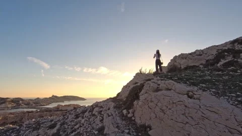A girl shooting a sunset on top of a mountain. Stock Footage 253513402