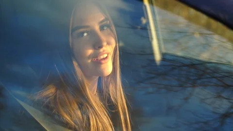 Girl singing while sitting in the car, shooting through the window 库存影片 88676725