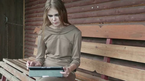 Girl sits on a bench with a tablet Vídeo Stock 73220261