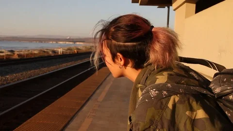 Girl sits down during long wait for train Stock Footage 123144066