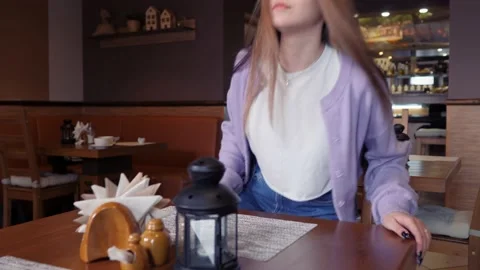 Girl sits down at a table in the cafeteria. Stock Footage 158056891