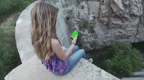 Girl Sits on Edge Using Smart Phone with Green Screen. Stock-Footage 49999860