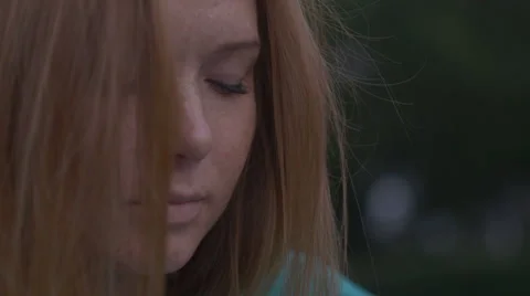 Girl sits musingly on the grass Видео 67315392