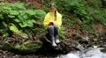 Girl sits by the river and communicates via smartphone HD Footage