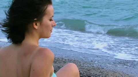 Girl sits on the sea Stock Footage
