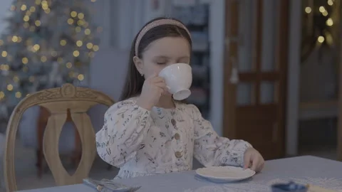 A Girl Sits at the Table and Drinks Tea Stock Footage 295600551