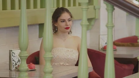 The girl sits at the table Stock Footage 73034288