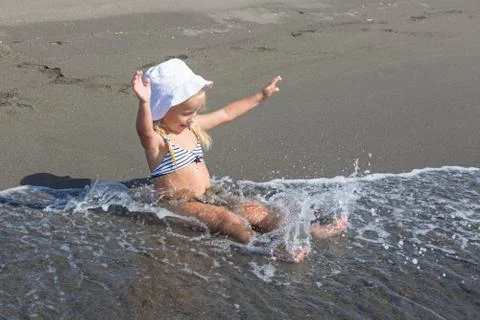 Girl sits at the water's edge Stock Photos