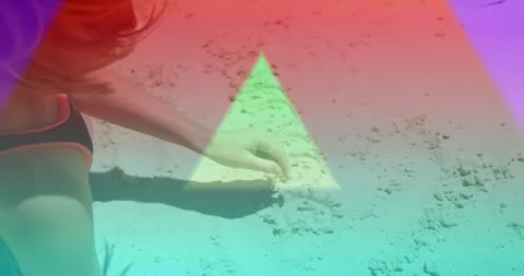 Girl sitting on beach sand using finger drawing marks right for design, triangle Stock Footage 330958686