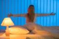 The girl sitting in the bed and gesture. Evening night time Photo