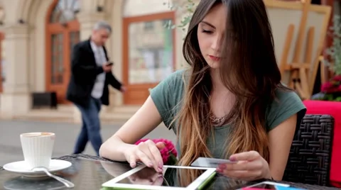 Girl sitting behind the table in cafe restaurant. She is using tablet Stock Footage 50035280