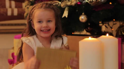 Girl Sitting by the Christmas Tree with Present Box Stock Footage 57881069