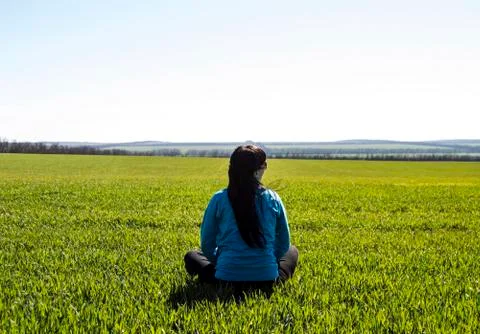Girl sitting on the field Stock Photos