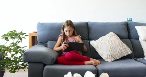 Girl sitting at home using a tablet Stock Footage 271063172