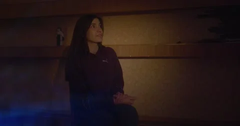 Girl sitting looking at projected light in warm cozy room Stock Footage 325092162