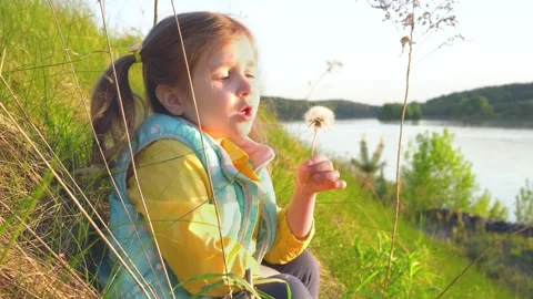 The girl is sitting in the rays of the setting sun. Video stock 154946793
