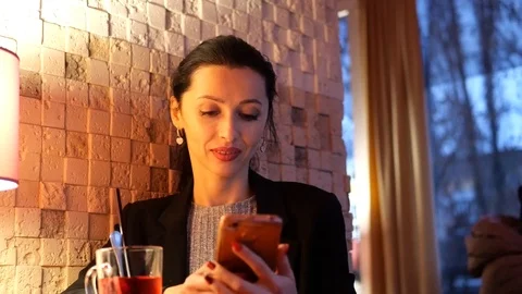 Girl sitting with a smartphone in a cafe Stock Footage
