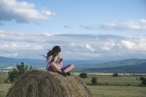 A girl sitting on a stack of hay Stock Photos