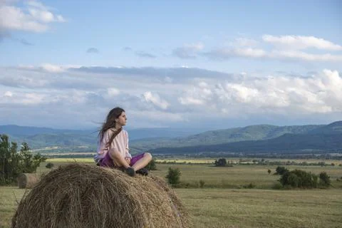 A girl sitting on a stack of hay Stock Photos