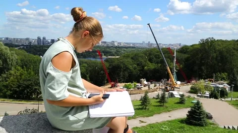 The girl is sitting on the step in front of the construction site. Stock Footage 97267633