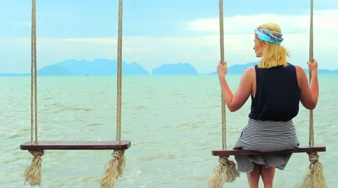 Girl sitting on a swing Stock Footage 64215102