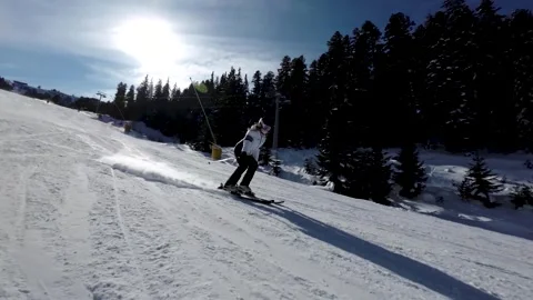 Girl Skier going down a ski slope during sunny winter weather in 4K Stock Footage 245949005