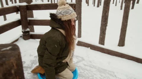 Girl Sledding down Ice Slide during Winter Outdoor Activity 스톡 동영상 341859345
