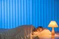 The girl sleeping on the bed. Evening night time Photo