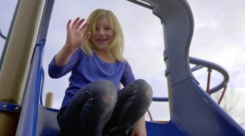 Girl on slide waves at the camera Stock Footage 56846458