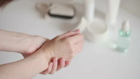 The girl slowly rubs the moisturizer on her hands and fingers. Hand and nail Stock Footage