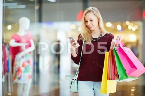 Girl with smartphone and paperbags after shopping Stock Photos