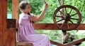 Girl with smartphone sits near wooden wheel HD Footage