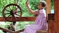 Girl with smartphone sits near wooden wheel HD Footage