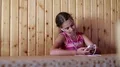 Girl with smartphone sits at table, listens to music and sings a song HD Footage