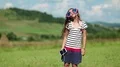 Girl with smartphone stands on meadow, listens to music, dances and sings a song HD Footage