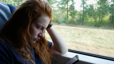 Girl with a smartphone in a train by the window Stock Footage 114830764