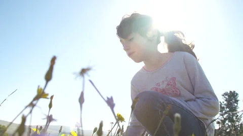 Girl smelling a yellow flower in the sun Stock Footage 59359326