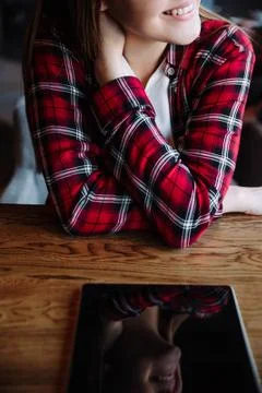 The girl smiles,the reflection in the tablet Fotos de archivo