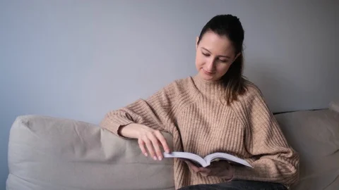 The girl smiles when reading a book Stock Footage
